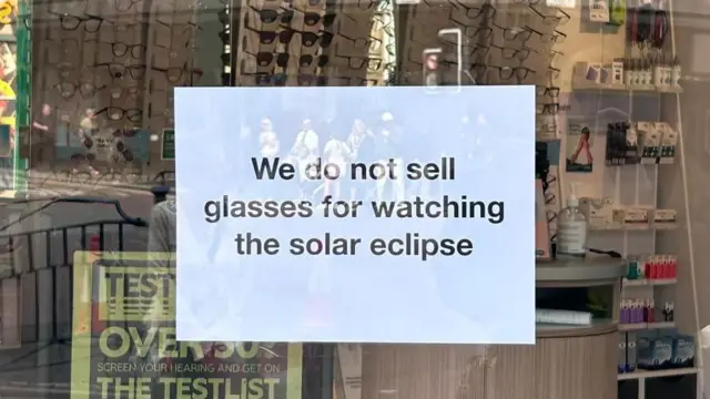 A sign which reads "we do not sell glasses for watching the solar eclipse".