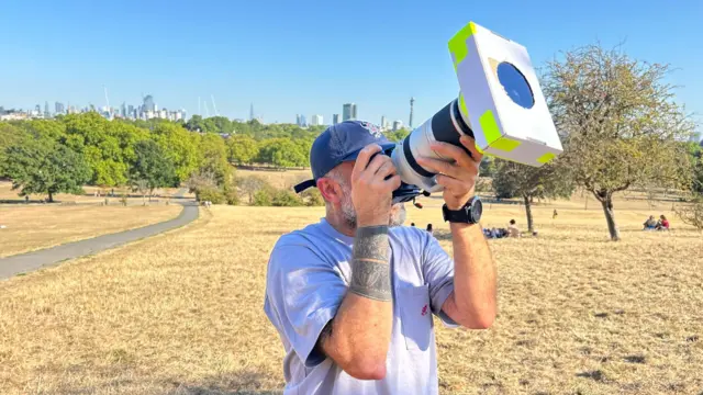 professional photographer Nergal Youkhana pointing a camera at the sky