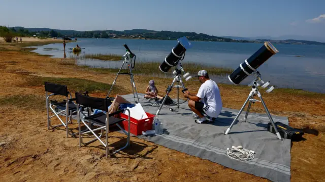 A Frenchman, Leyssalle Anthony, 39, prepares a telescope to view the total solar eclipse from the beach, in Arija, Spain