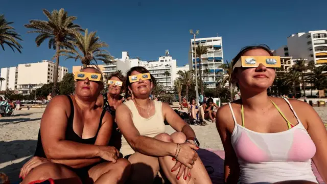 Women from Cologne in Germany test their protective glasses at El Arenal beach in Mallorca.