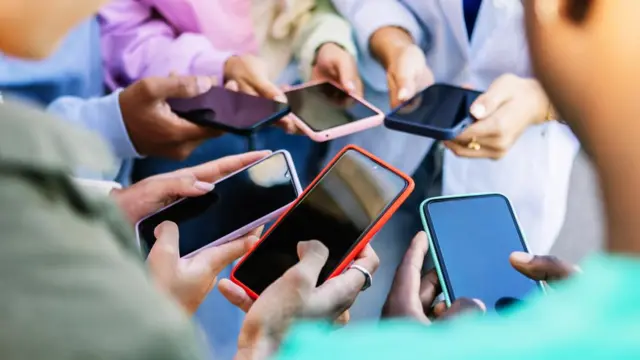 A group of people holding mobile phones