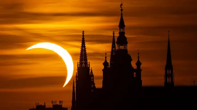 The Prague skyline silhouetted against the partial solar eclipse.