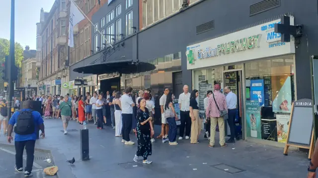 eople form a long queue for solar eclipse glasses outside Grafton Pharmacy on Tottenham Court Road, London, 12/08/2026