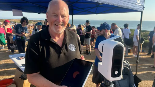 Chris Meadows with his telescope on Rest Bay, Porthcawl