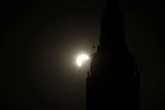 The Sun during a solar eclipse is visible behind the Elizabeth Tower in London