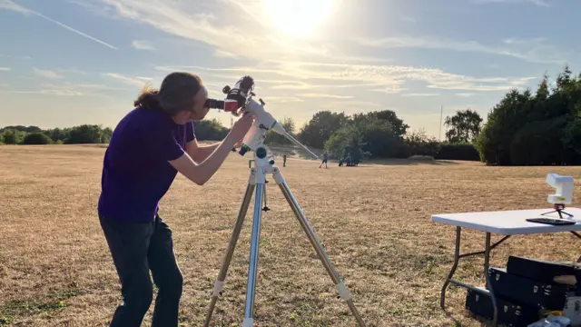 Technicans adjusting telescope in field