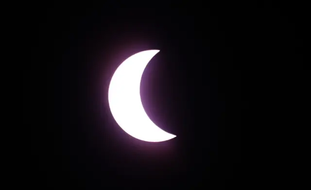 Crescent sun eclipse against black sky