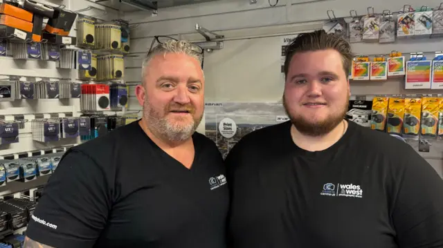 Nick Turner, owner of Camera Centre UK in Cardiff, in his shop alongside a fellow colleague