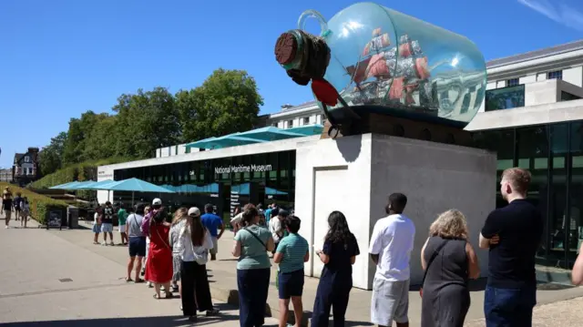 People queue to buy solar eclipse glasses outside the National Maritime Museum in Greenwich