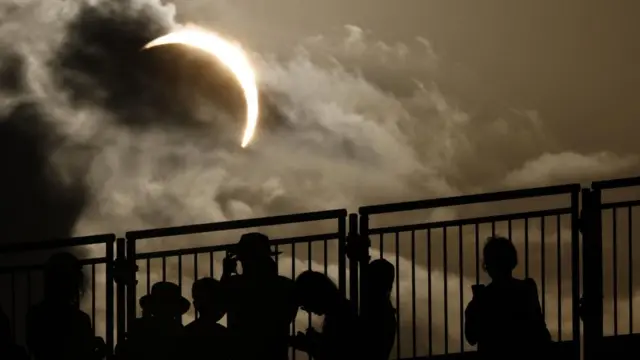 People watch the solar eclipse during the European Athletics Championships, Birmingham.