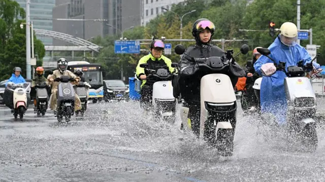 People riding their motorcycles in the rain