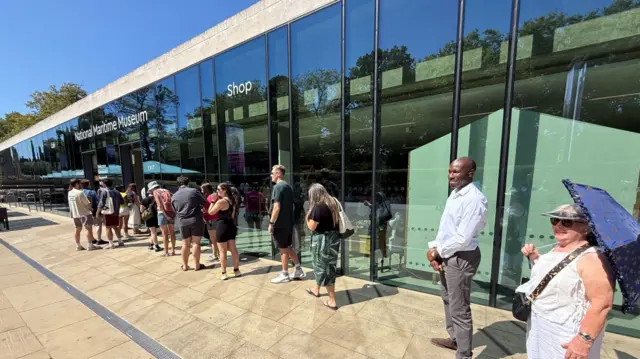 A queue of people waiting outside the  National Maritime Museum in Greenwich waiting to secure a pair of eclipse glasses