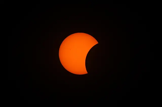 Orange eclipse against black sky