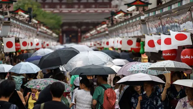 Tourists holding umbrellas under the rain in Tokyo's Asakusa district