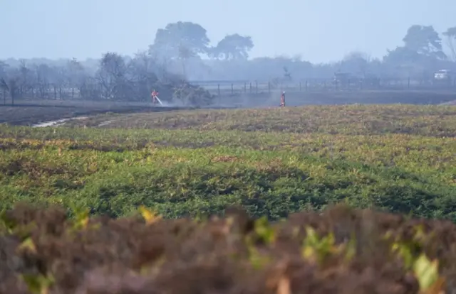 Firefighters damping down fire