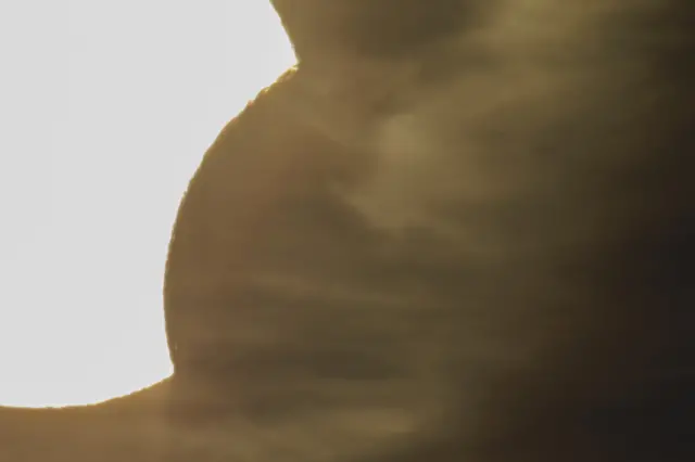 Hazy partial eclipse with clouds