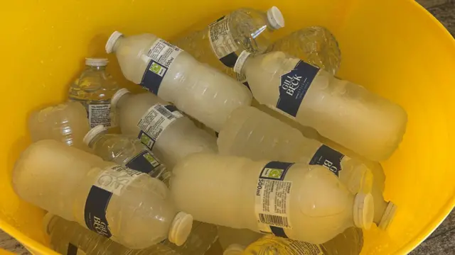Frozen water bottles in yellow bucket