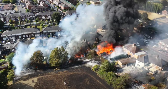 An aerial photo of a large fire at the rear of a property in a built-up residential area.