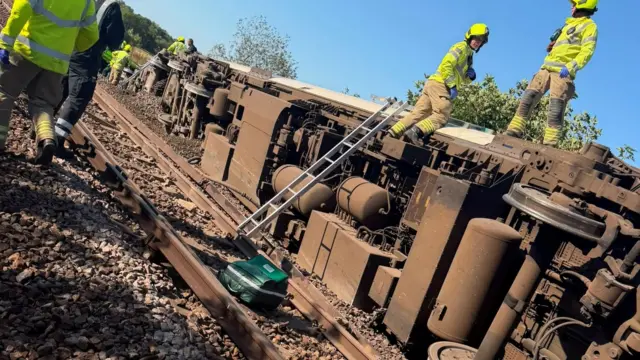 The derailed train on its side