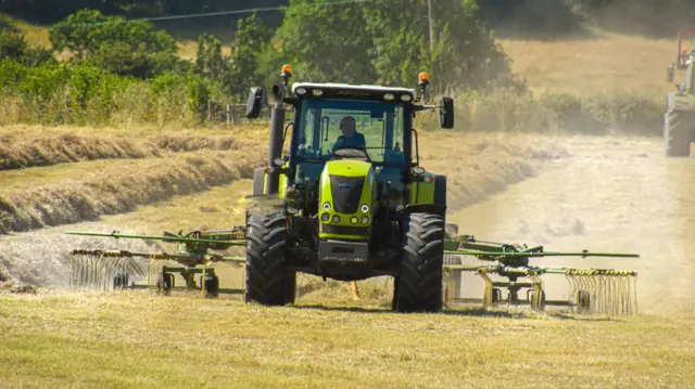 A farmer in a field in his tractor