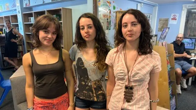 Triplets Scarlett, Tabby and Grace smile as they speak to the BBC