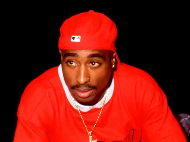 Tupac Shakur wearing red baseball hat and a red jumper and neck chain poses for a portrait during the 1994 Source Awards on April 25, 1994 at the Paramount Theatre in New York, New York