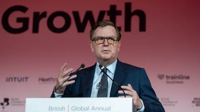 Shadow chancellor Mel Stride in a dark suit, shirt and tie mid-speech while delivering an address on stage