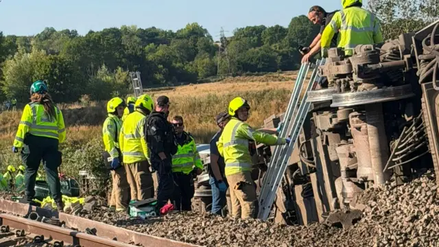 Emergency workers inspecting the scene of the derailment