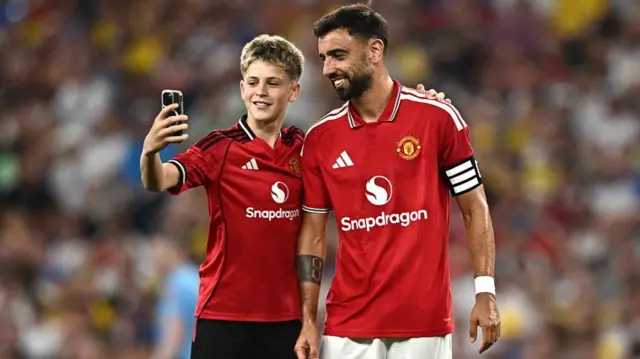 Bruno Fernandes poses for a photo with a fan