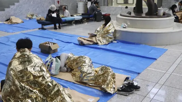 People stay at a makeshift evacuation centre set up at the Chiba prefectural government office