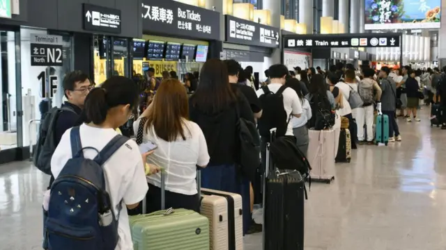 Stranded travellers queue in Narita International Airport