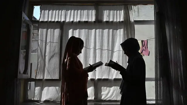 This photograph taken on August 6, 2026 shows Afghan girls attending a lesson by their father at their residence in Kabul.