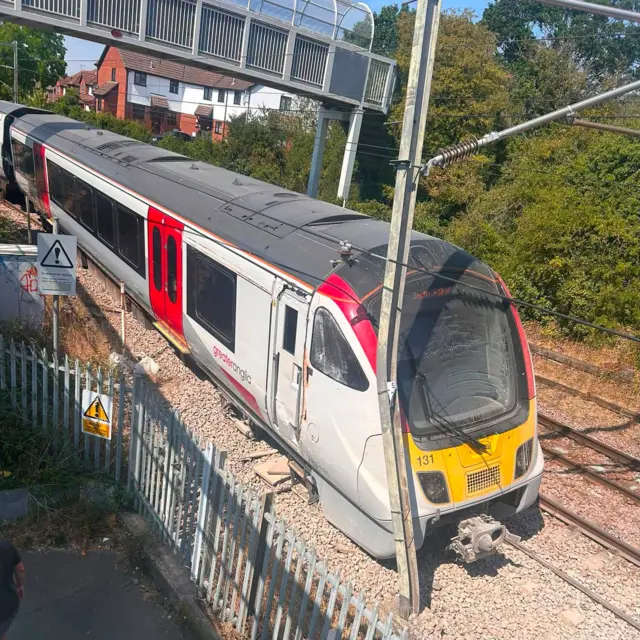 An image of a derailed train that has come off the tracks next to a fence in Essex.
