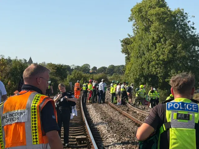 People walking on train tracks.