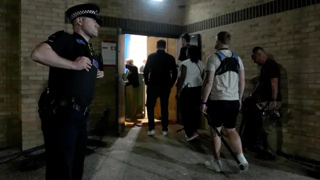 A police officer stands outside leisure centre as people enter