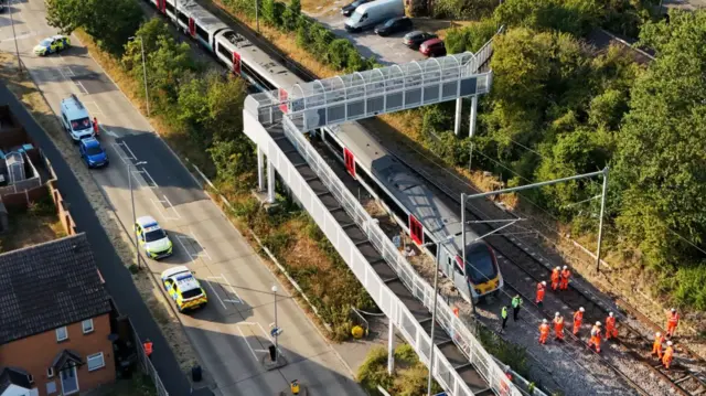 A drone image showing police and railway workers assessing the train and railway tracks.