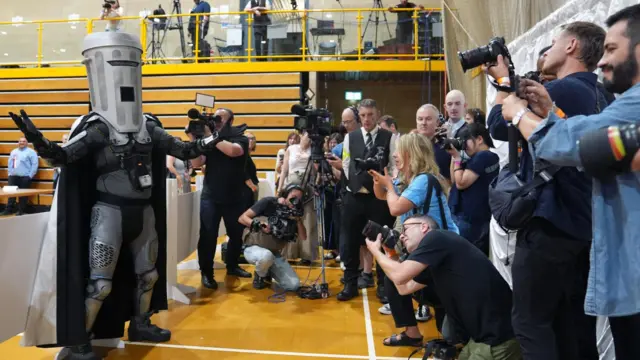 Count Binface arrives for the Clacton by-election at Clacton Leisure Centre in Essex. The by-election was triggered by local MP and Reform UK leader Nigel Farage quitting in protest at the scrutiny of his finances from the press and the parliamentary authorities. Picture date: Friday August 14, 202