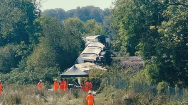 Train carriages in an embankment, close to a tent.