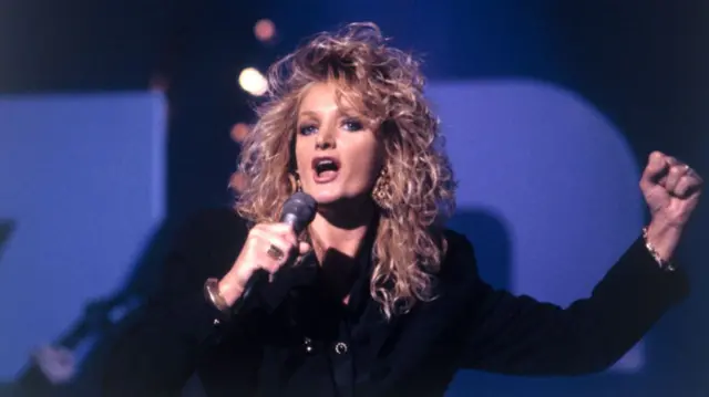 Bonnie Tyler singing into a microphone