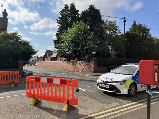 A close up of the road closure, showing a police car parked up directly inside the cordon
