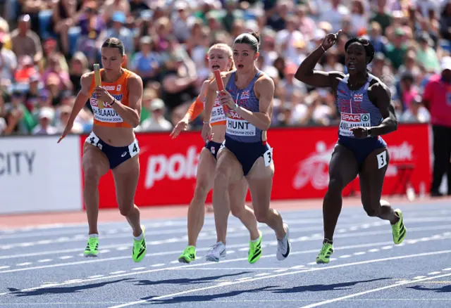 Amy Hunt of Team Great Britain receives the baton from Kristal Ama-Awuah