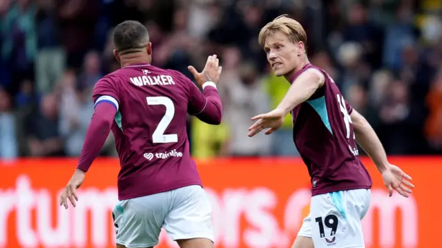 Zian Flemming (right) holds his arm out to Kyle Walker