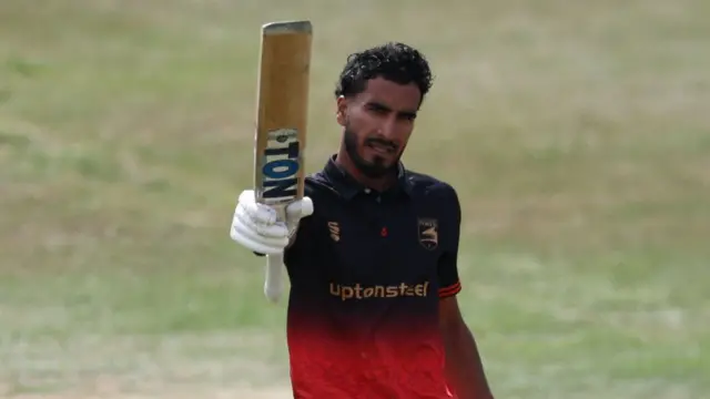 Hamza Shaikh raises his bat for his century
