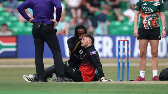 Ben Cox is treated after being struck by Haseeb Hameed's bat