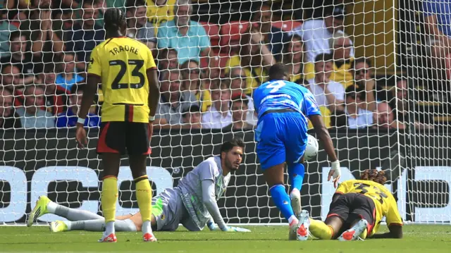 Cyle Larin (centre) bends forward as the ball go in the net and three Watford players watch on