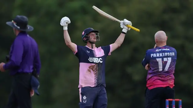 Luke Hollman celebrates with arms in the air