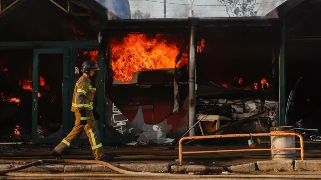 A firefighter walks past flames inside a damaged building in Kyiv.
