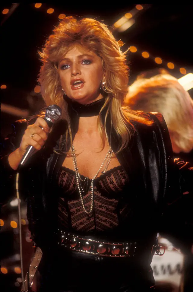 Bonnie Tyler in black singing on stage