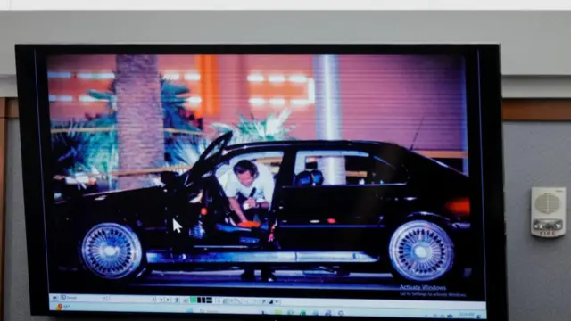 An investigator searching a black car