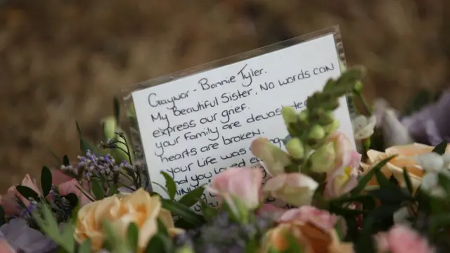 A message inside a floral tribute is pictured.